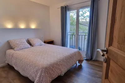 a bedroom with a bed and a large window at Appartement Confortable & Lumineux in Lambesc