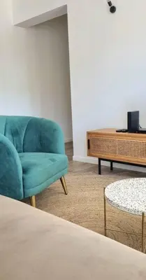 a living room with a blue chair and a table at Appartement Confortable & Lumineux in Lambesc