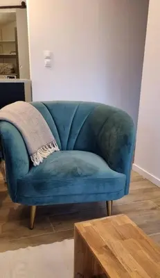 a blue couch in a living room with a table at Appartement Confortable & Lumineux in Lambesc