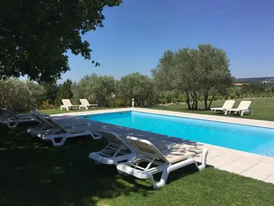 a swimming pool with two lounge chairs and a swimming pool at La Bastide au Ventoux in Bédoin