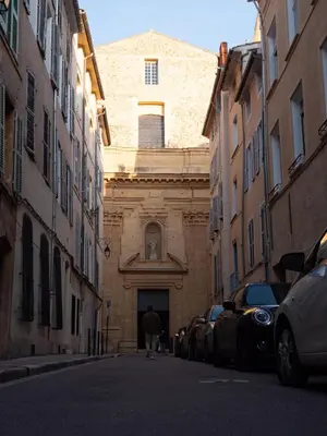 a man walking down a street in front of a building at Le Spacieux - Un Voyage en Provence- Offre de lancement in Aix-en-Provence