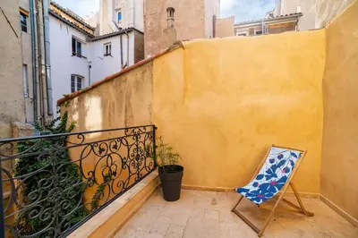 a chair sitting on a balcony next to a wall at Le Spacieux - Un Voyage en Provence- Offre de lancement in Aix-en-Provence
