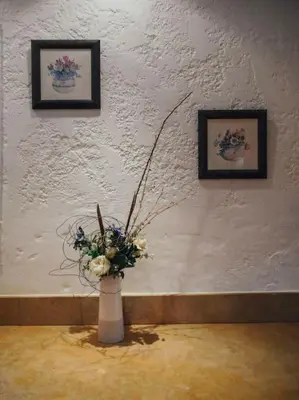 a vase with flowers in a room with two pictures at Maison de campagne avec Piscine in Pernes-les-Fontaines
