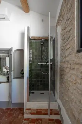 a bathroom with a shower with a green tile wall at Grande maison de charme au coeur de Goult in Goult