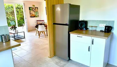 a kitchen with a refrigerator and a table at Villa la Farigoule in Carpentras