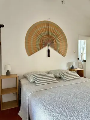 a bedroom with a bed with a large umbrella on the wall at La maison Haut-perché townhouse with view and jacuzzi in Saumane-de-Vaucluse