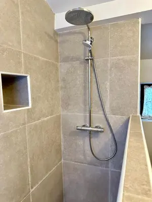 a shower with a shower head in a bathroom at La maison Haut-perché townhouse with view and jacuzzi in Saumane-de-Vaucluse