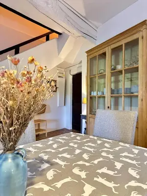 a dining room with a table with a vase on it at La maison Haut-perché townhouse with view and jacuzzi in Saumane-de-Vaucluse