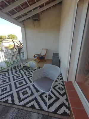 a room with a chair and a rug on a balcony at Luberon sud in La Bastidonne