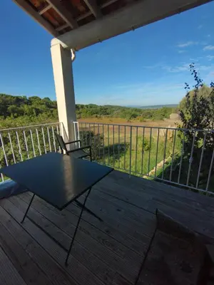 a black table and chairs on a deck with a view at Luberon sud in La Bastidonne