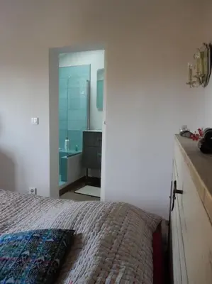 a bedroom with a bed and a bathroom with a mirror at Une maison de famille dans le Luberon in Bonnieux