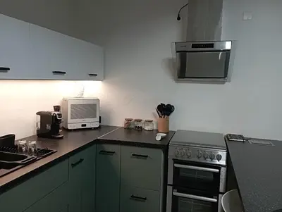 a kitchen with a stove and a microwave at maisonnette provençale piscine le petit colibri in Les Cordiers