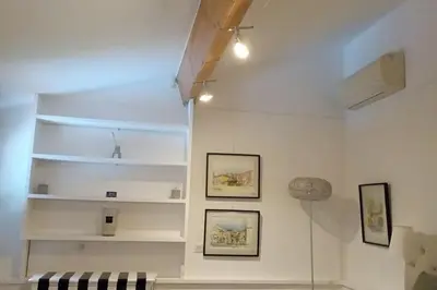 a room with white walls with shelves and a couch at maisonnette provençale piscine le petit colibri in Les Cordiers