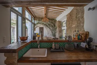 a kitchen with a sink and a stone wall at Maison d'exception au cœur de Goult in Goult