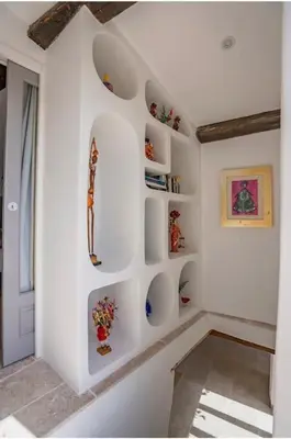 a white room with shelves on the wall at Maison d'exception au cœur de Goult in Goult