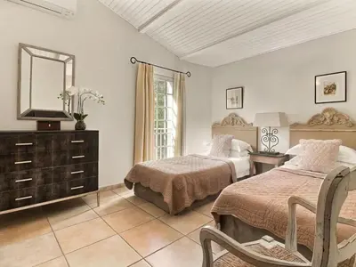 a bedroom with two beds and a mirror and a dresser at Les Blayons - Exclusive Pool Villa Stunning View in Bonnieux