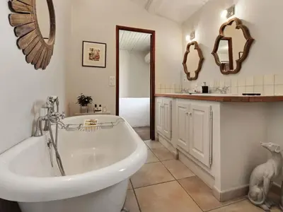 a bathroom with a tub and a sink and mirrors at Les Blayons - Exclusive Pool Villa Stunning View in Bonnieux