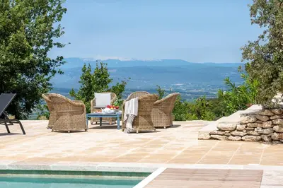 a group of wicker chairs and a table next to a pool at La Becasse Heritage Pool Manor in Bonnieux