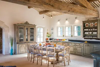 a kitchen with a table and chairs in a room at La Becasse Heritage Pool Manor in Bonnieux