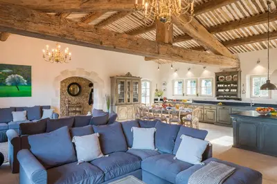 a living room with a blue couch and a kitchen at La Becasse Heritage Pool Manor in Bonnieux