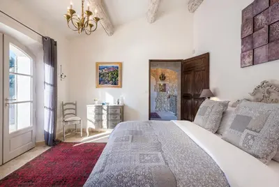 a bedroom with a large bed and a window at La Becasse Heritage Pool Manor in Bonnieux