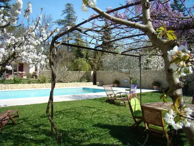 a garden with a table and chairs and a swimming pool at Chambres d'hôtes 