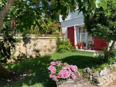a garden with pink flowers in front of a house at Chambres d'hôtes 