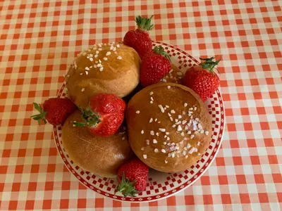 a plate of strawberries and buns on a table at Chambres d'hôtes 