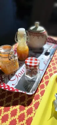 a table with jars of honey on a table at Chambres d'hôtes 
