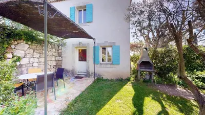 a house with a table and a grill in the yard at Lei Meissoun in Mallemort