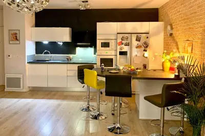 a kitchen with a counter and chairs in a room at Bel appartement 1 chambre - résidence de standing in Aix-en-Provence