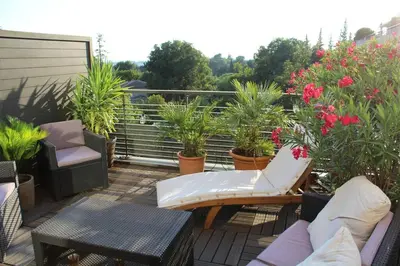 a balcony with chairs and tables and potted plants at Bel appartement 1 chambre - résidence de standing in Aix-en-Provence
