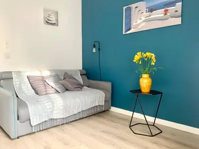 a living room with a couch and a vase with flowers at Bel appartement 1 chambre - résidence de standing in Aix-en-Provence