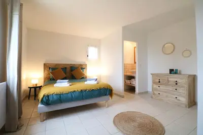 a bedroom with a bed and a dresser at Villa l'Hestia avec piscine à l'Isle-sur-Sorgue in LʼIsle-sur-la-Sorgue