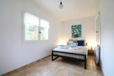 a bedroom with a bed and a window at Villa l'Hestia avec piscine à l'Isle-sur-Sorgue in LʼIsle-sur-la-Sorgue