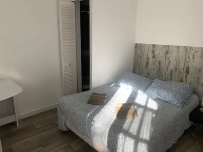 a bedroom with a bed with a wooden head board at Studio indépendant en RDC de villa, parking in Pertuis