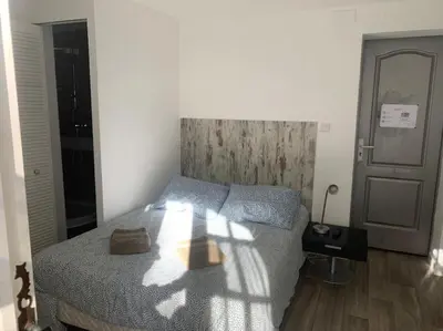 a bedroom with a bed and a wooden floor at Studio indépendant en RDC de villa, parking in Pertuis