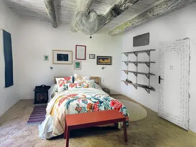 a bedroom with a bed with a floral bedspread at Les voûtes du vieux village in Lauris