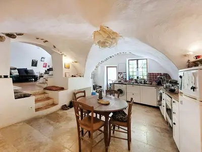 a kitchen with a table and chairs in a room at Les voûtes du vieux village in Lauris