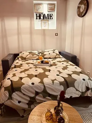 a bedroom with a bed with white flowers on it at Studio Oasis de paix centre Aix en Provence in Aix-en-Provence
