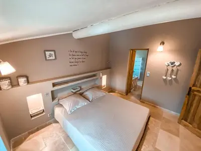 a bedroom with a white bed in a room at La Petite Colline in Apt