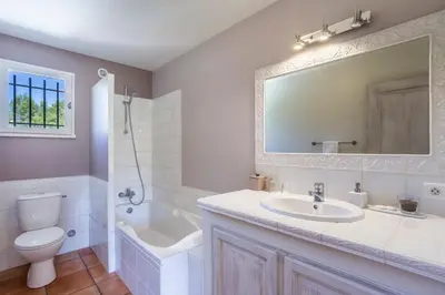 a bathroom with a sink and a shower with a mirror at Les Douze Oliviers in Ménerbes