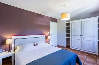a bathroom with a sink and a bedroom with a bed at Les Douze Oliviers in Ménerbes