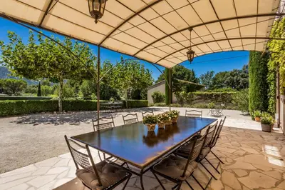 an outdoor dining area with a table and chairs at Les Douze Oliviers in Ménerbes