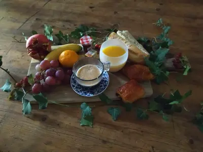 a table with a plate of food with a cup of coffee at Ecurie Le Pas du Loup in Caumont-sur-Durance