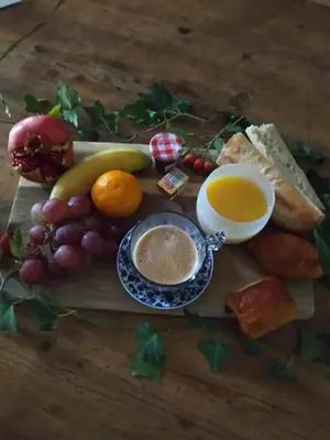 a plate of food with bread and fruit and a cup of coffee at Ecurie Le Pas du Loup in Caumont-sur-Durance
