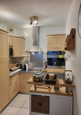 a kitchen with wooden cabinets and a stove top oven at Le temps d'un instant in Salon-de-Provence