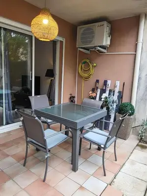 a glass table and chairs on a patio at Le temps d'un instant in Salon-de-Provence