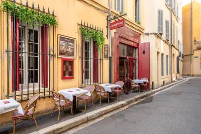 an alley with tables and chairs on a street at Suite cosy dans le centre historique in Aix-en-Provence