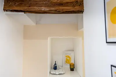 a shelf in a room with a book and vases at Suite cosy dans le centre historique in Aix-en-Provence